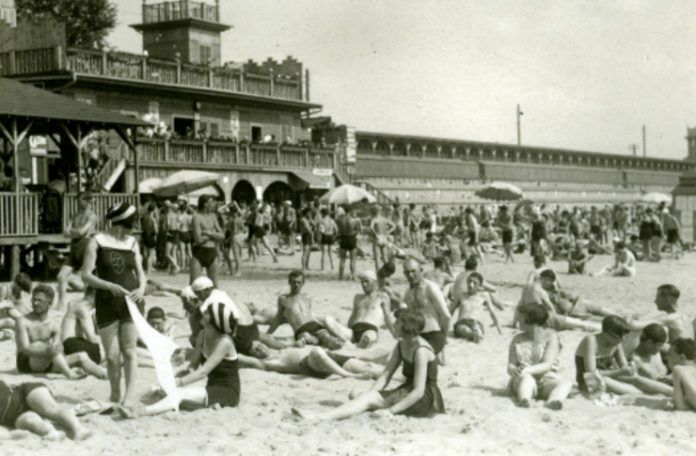Czarno-białe zdjęcie sprzed kilkudziesięciu lat przedstawiające plażowiczów