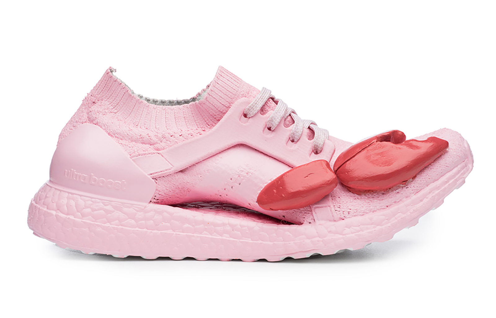 Fotografia reklamowa ukazując buty firmy Adidas, model Ultraboost w kolorze różowym z czerwonymi szczypcami homara na nosku buta.