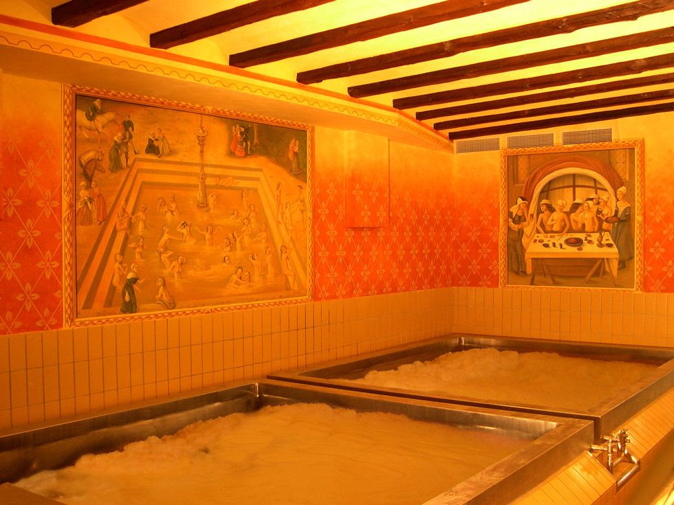 Zdjęcie dwoch basenów o rozm. 4x4m wypełnionych wodą oraz austriackim browarem Starkenberger. Na ścianach widać dodatkowo grafiki. Przeważa kolor pomarańczowy i żółty na zdjęciu.