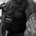 Czarno-biały portret czarnoskórego mężczyzny z siatką na twarzy