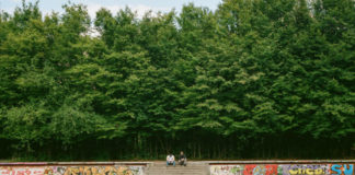 Widok na zielony las, beton i dwóch chłopaków w oddali