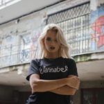 Blondynka w czarnej koszulce z napisem WANNABE na tle Graffiti