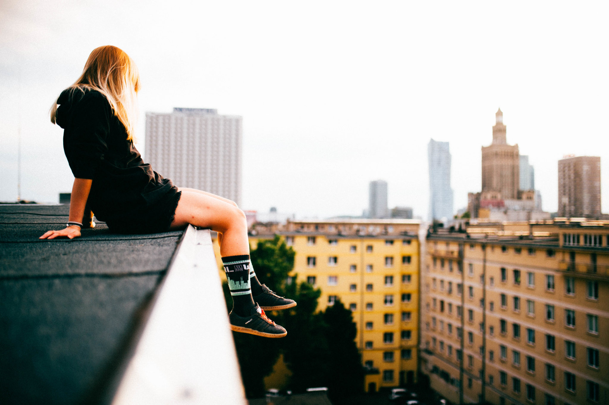 Dziewczyn siedząca na krawędzi budynku