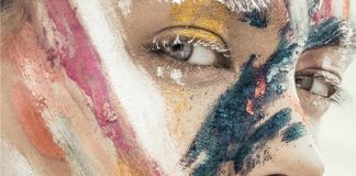 Portret dziewczyny z pomalowaną różnymi kolorami farb twarzą