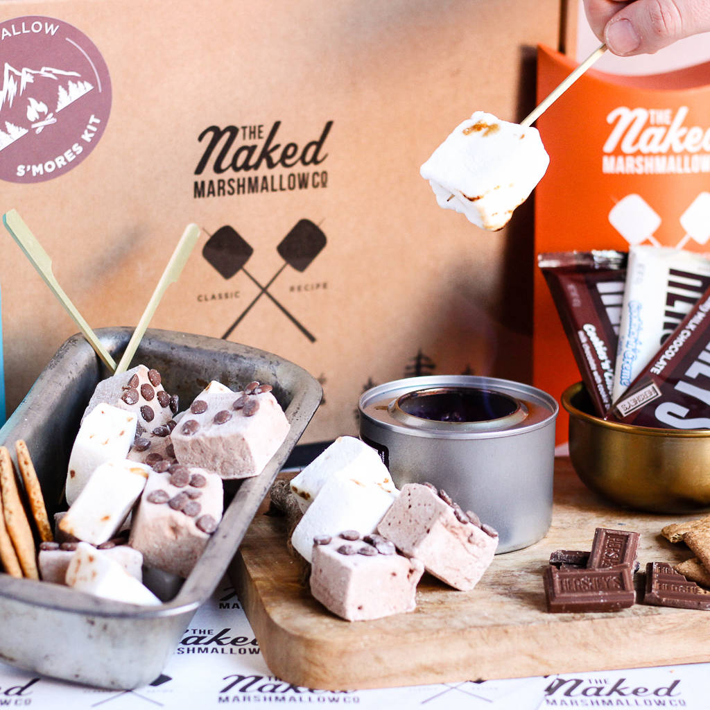 Pianki z czekoladą na tle pudełka firmy The Naked Marshmallow.