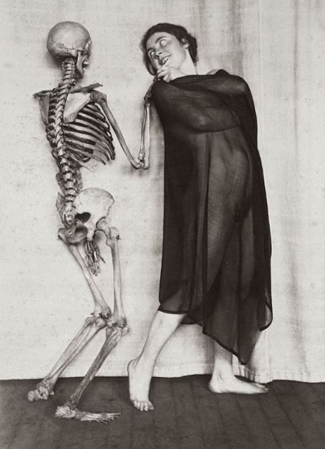 Półnaga kobieta pozująca ze szkieletem