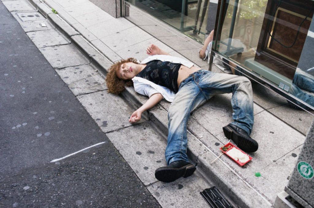 pijany japończyk śpiący na chodniku