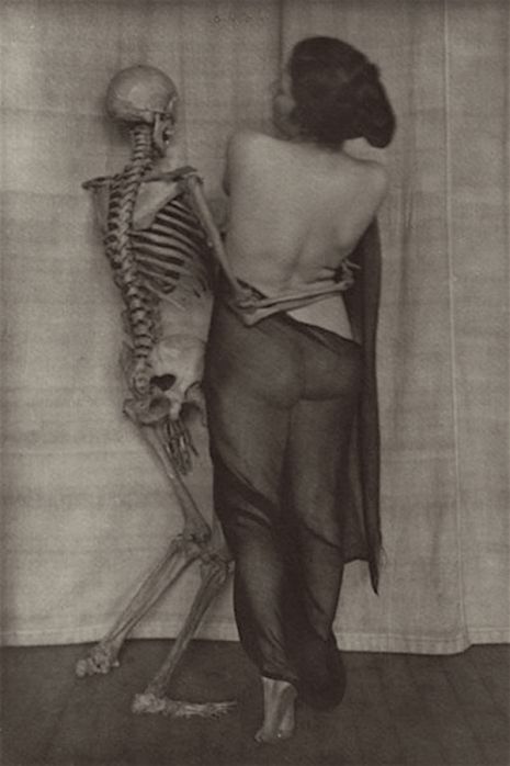 Półnaga kobieta pozująca ze szkieletem