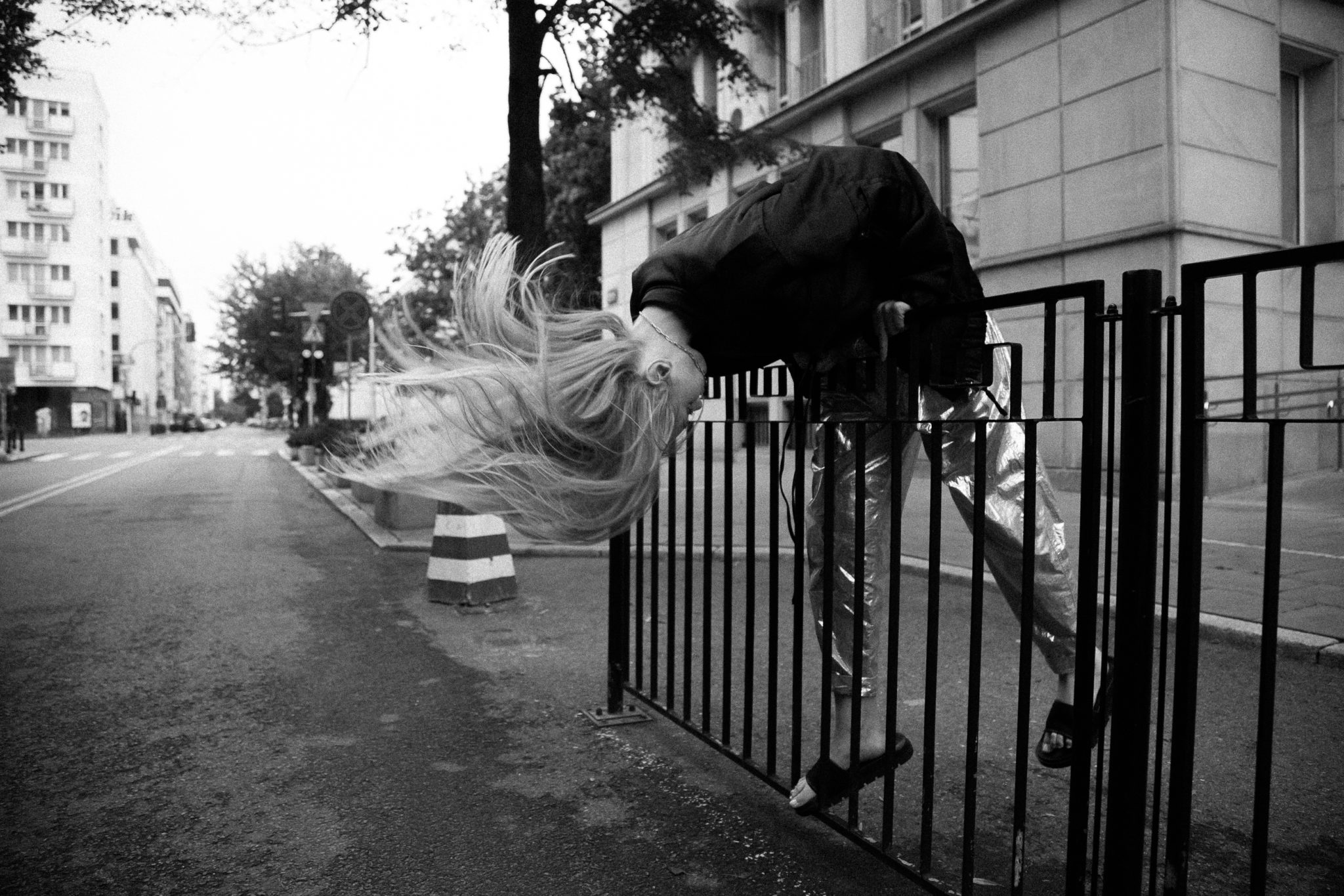 Czarno-białe zdjęcie dziewczyny przechylającej się przez barierkę