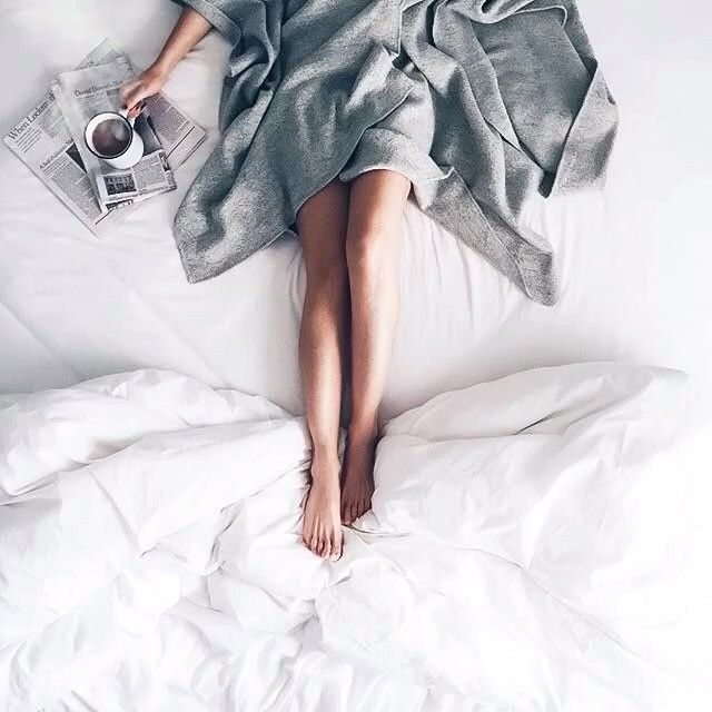 mała czarna kawa i gazeta porankiem w łóżku z dziewczyną w szlafroku i białej pościeli