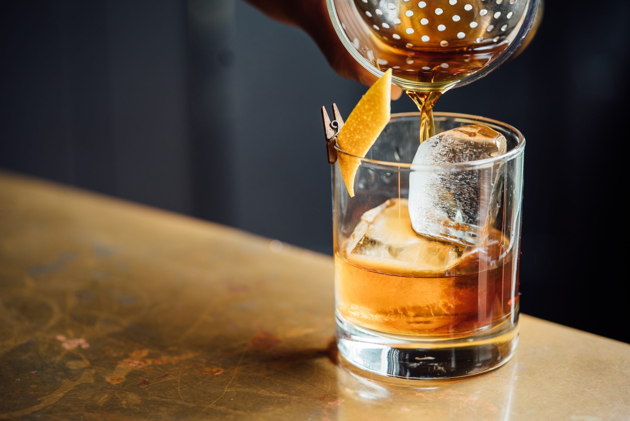Szklanka whisky z lodem, do któej nalewany jest alkohol