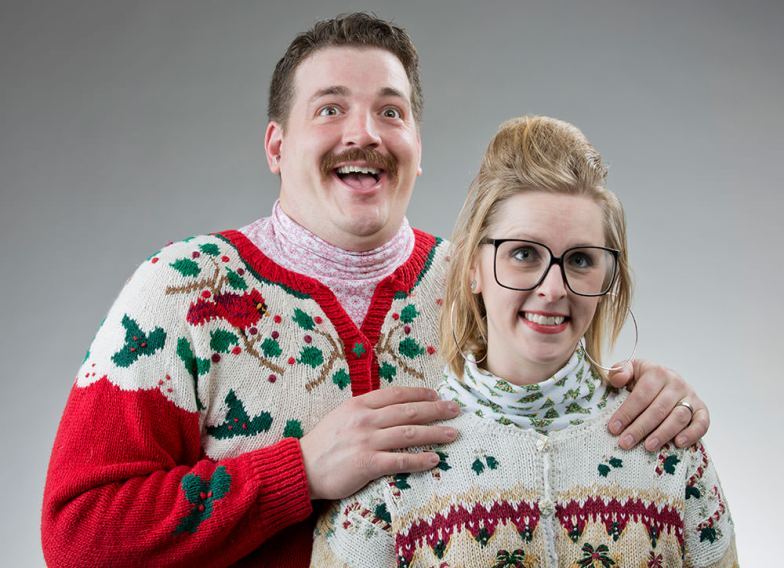 Kobieta i mężczyzna są przebrani w brzydkie świąteczne swetry.