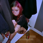 Dziewczyna z kolorowymi włosami siedząca w szafie