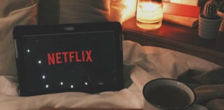 Tablet z włączonym Netflixem leżący na łózku