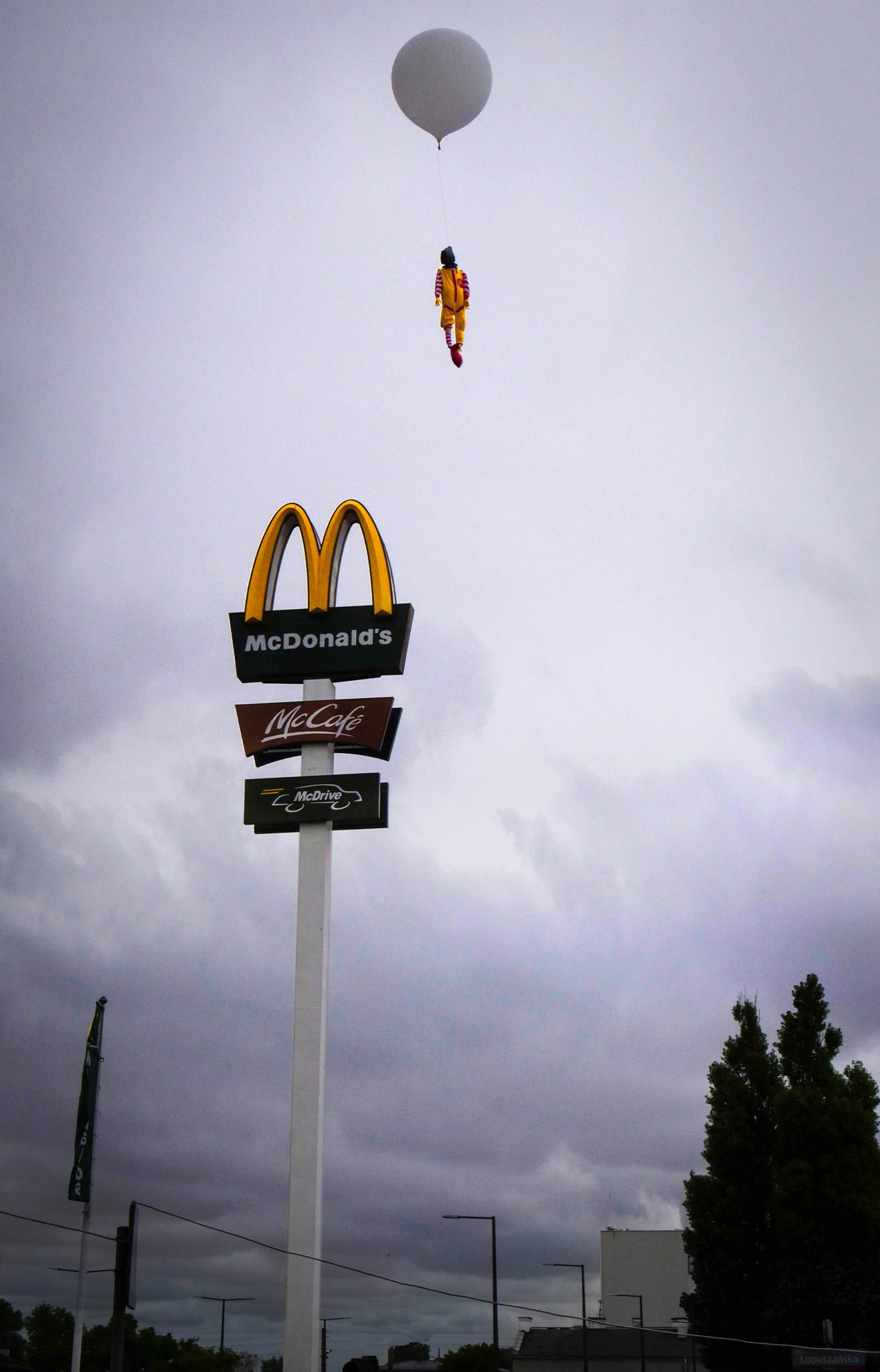 Ronald McDonald wiszacy na logo Mc Donalds