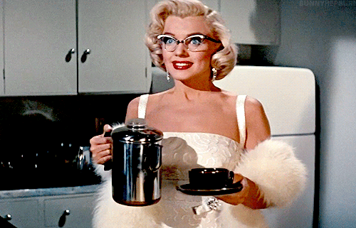 Marilyn Monroe w eleganckiej sukni trzyma czajnik i filiżankę
