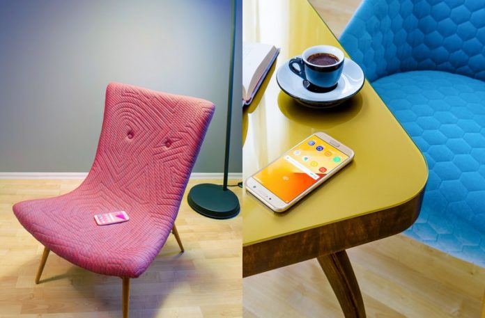 Różowy fotel z telefonem i żółty stolik z niebieskim fotelem