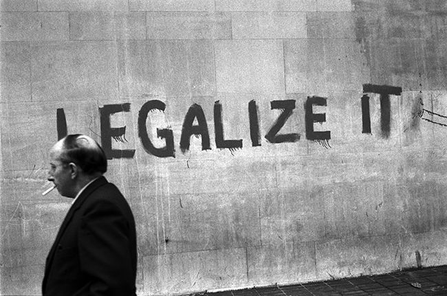 czarno-biale zdjecie muru z napisem ,,legalize it"