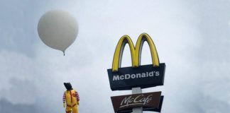 Ronald McDonald wiszacy na logo Mc Donalds