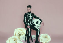 Mężczyzna w kostiumie szkieletu na różowym tle