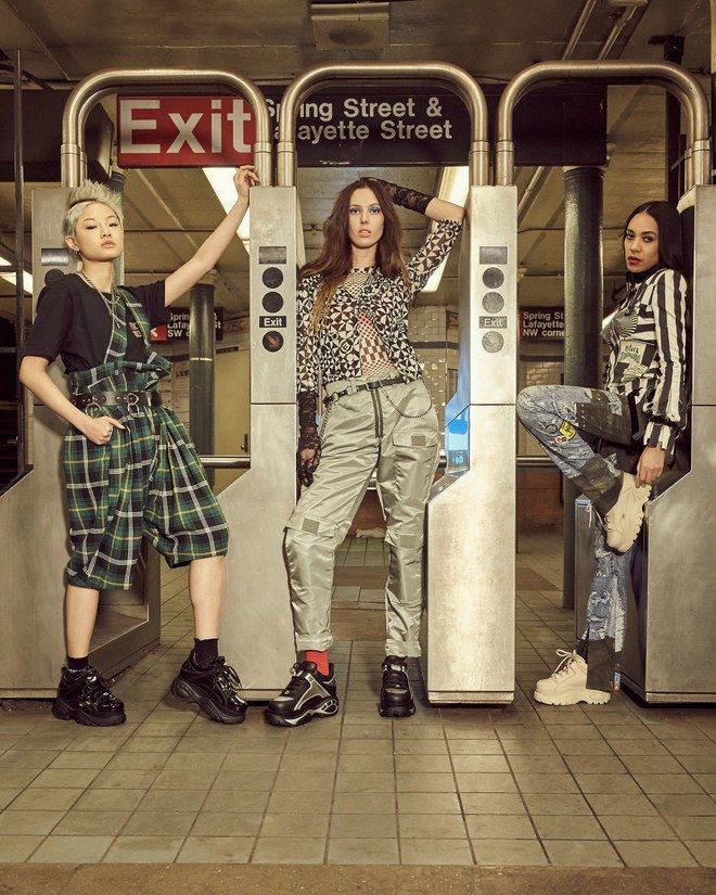 Trzy kobiety stojace przy wejsciu do metra