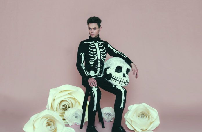 Mężczyzna w kostiumie szkieletu na różowym tle