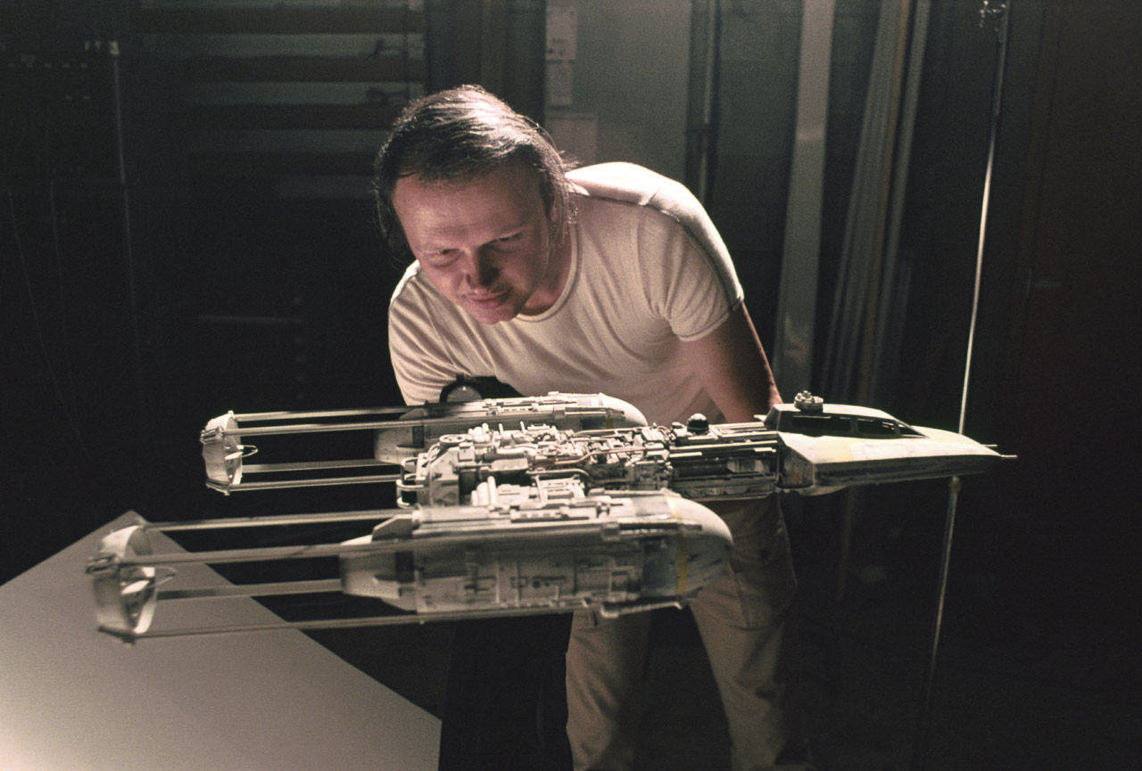 Dennis Muren pochylający się nad makietą statku kosmicznego z Gwiezdnych Wojen