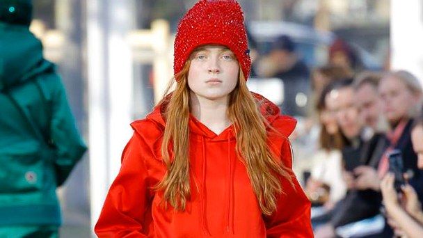 ruda długowłosa dziewczynka o bardzo jasnej skórze mająca na sobie czerwoną kurtkę i czapkę 