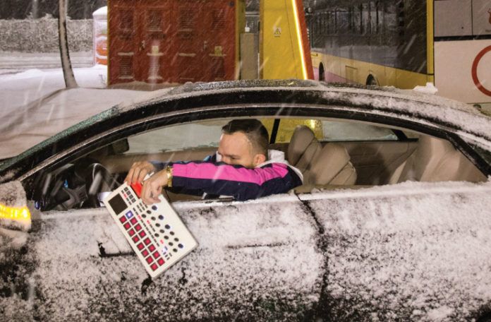 Mężczyzna w zaśnieżonym samochodzie z samplerem w ręku