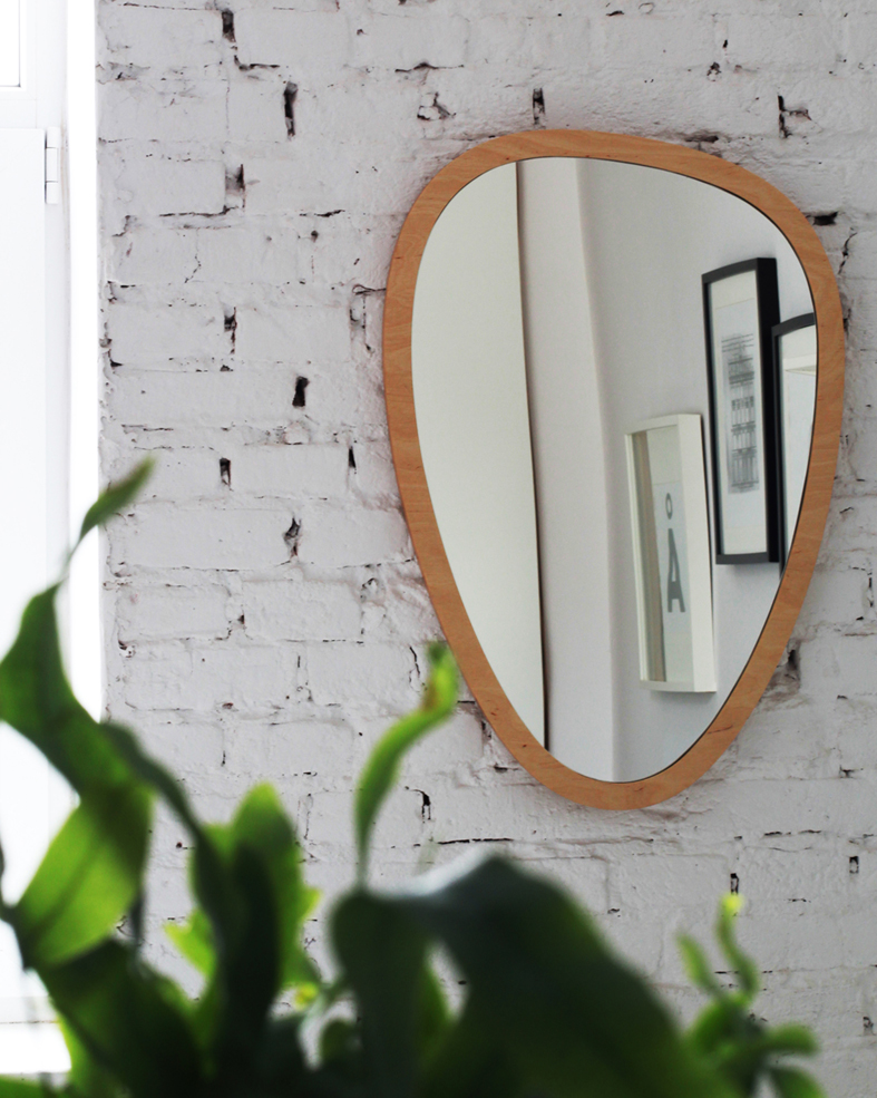 Zdjęcie lustra na białej ścianie z cegły i rośliny