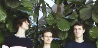 Trzech młodych chłopców na tle zielonych liści