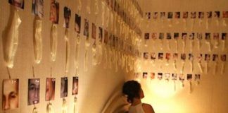 Dziewczyna siedząca na łóżku, dookoła na ścianach zużyte prezerwatywy