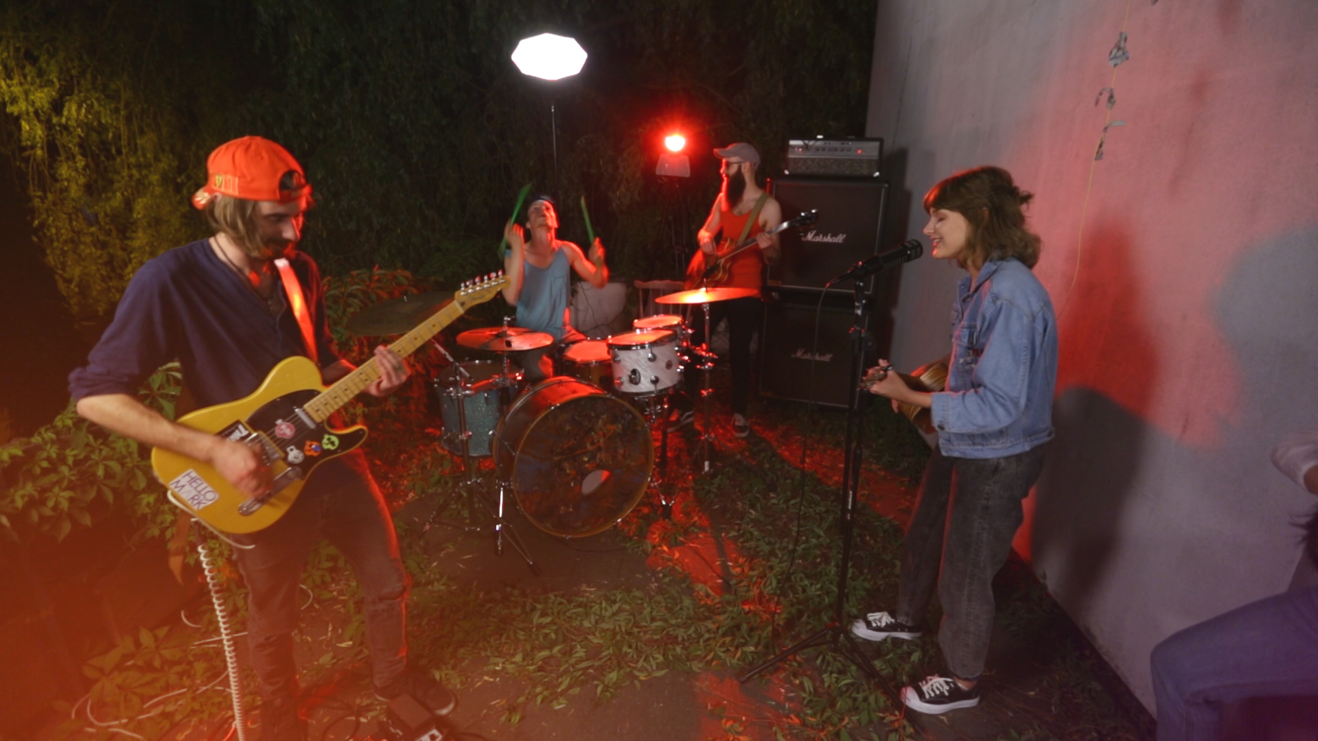 Na zdjęciu widac wieczorne jam session zespolu, w ktorym wokalistka jest dziewczyna a oswietla ich czerwone swiatlo