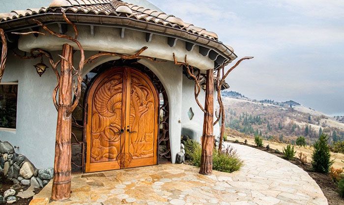 Dom z dużymi, rzeźbionymi drewnianymi drzwiami