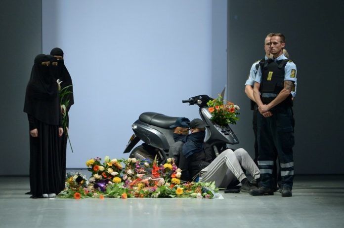 Policjanci i kobiety w niqabie obok skutera i kwiatów na wybiegu