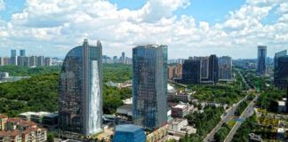 Sztuczny wodospad wypływający z wieżowca w Chinach, widok z panoramą dzielnicy