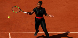Na zdjęciu znajduje się czarnoskóra tenisistka ubrana w czarny, zabudowany strój.