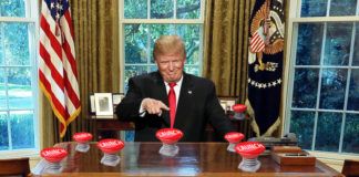 Trump za biurkiem z wieloma czerwonymi przyciskami z napisem launch