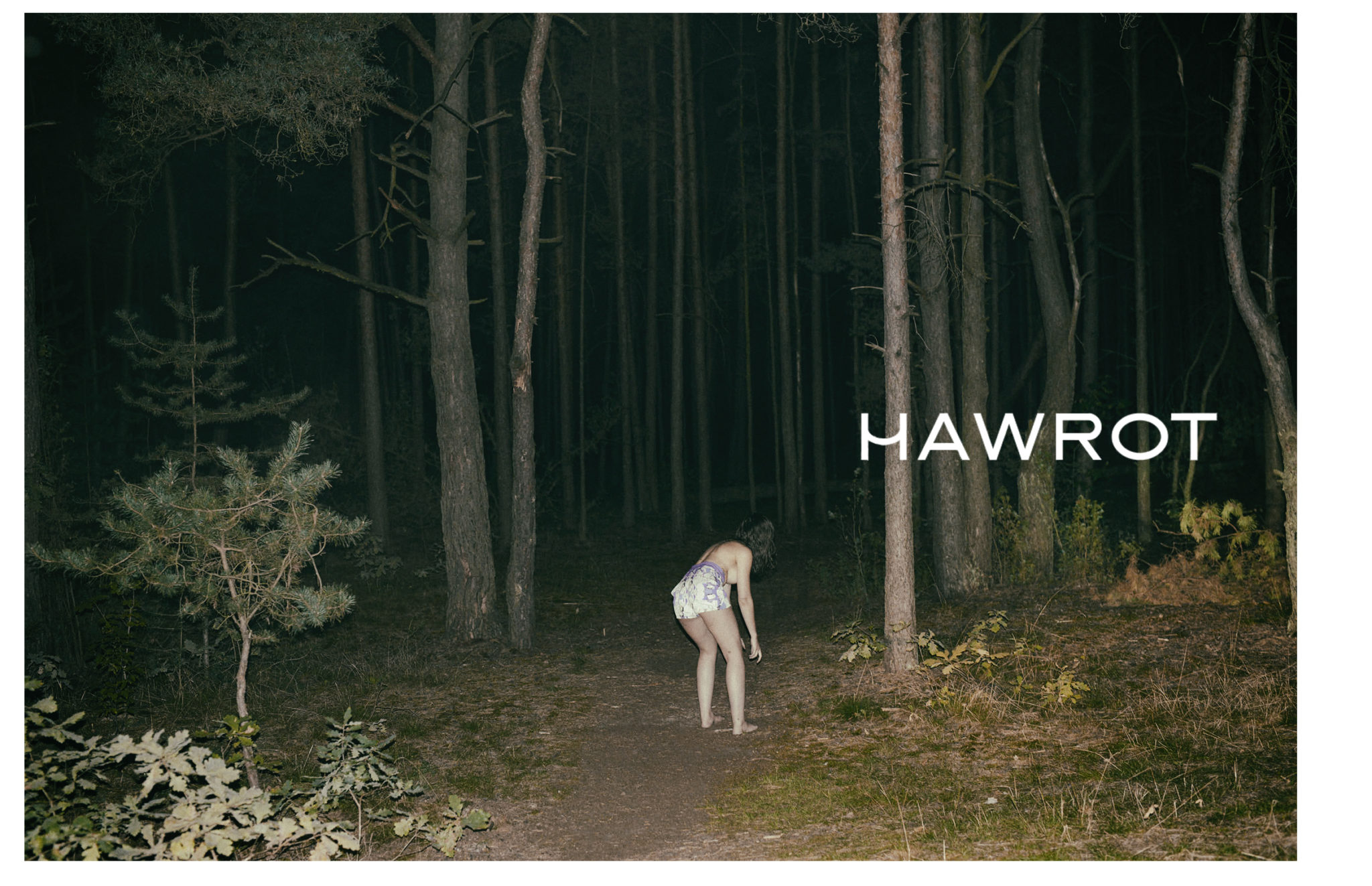 Dziewczyna stojaca w nocy w srodku lasu