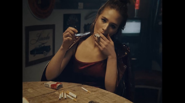 Dziewczyna z papierosami siedząca przy stole
