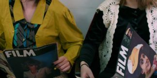 dwie dziewczyny czytające magazyny filmowe, jedna w żółtej marynarce, druga w czarnym swetrze, kadr ucina nogi i głowy