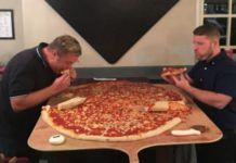 Dwóch mężczyzn z gigantyczną pizzą
