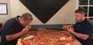 Dwóch mężczyzn z gigantyczną pizzą