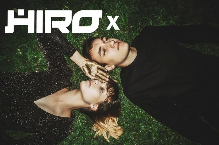 Dziewczyna z chłopakiem leżąca na trawie i logotyp HIRO