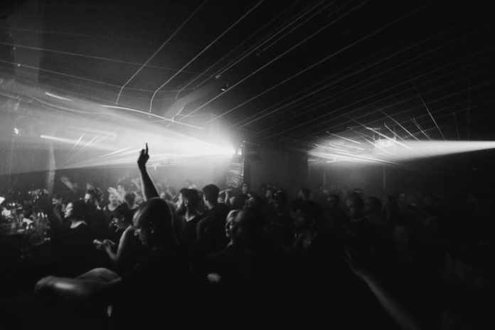 Czarno-białe zdjęcie ludzi bawiących się w klubie