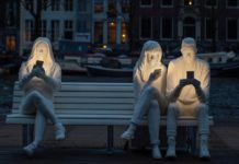 Rzeźba przedstawiająca trójkę ludzi ze smartfonami