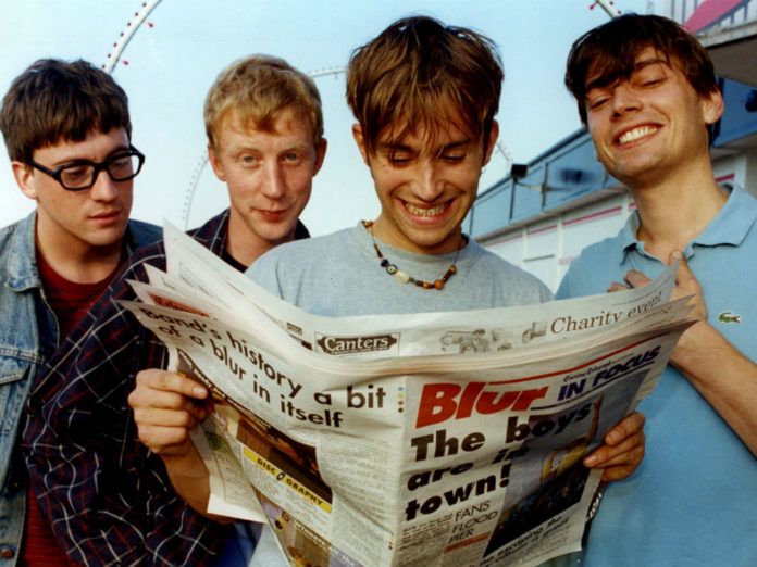 Czterech chłopaków czytających gazetę