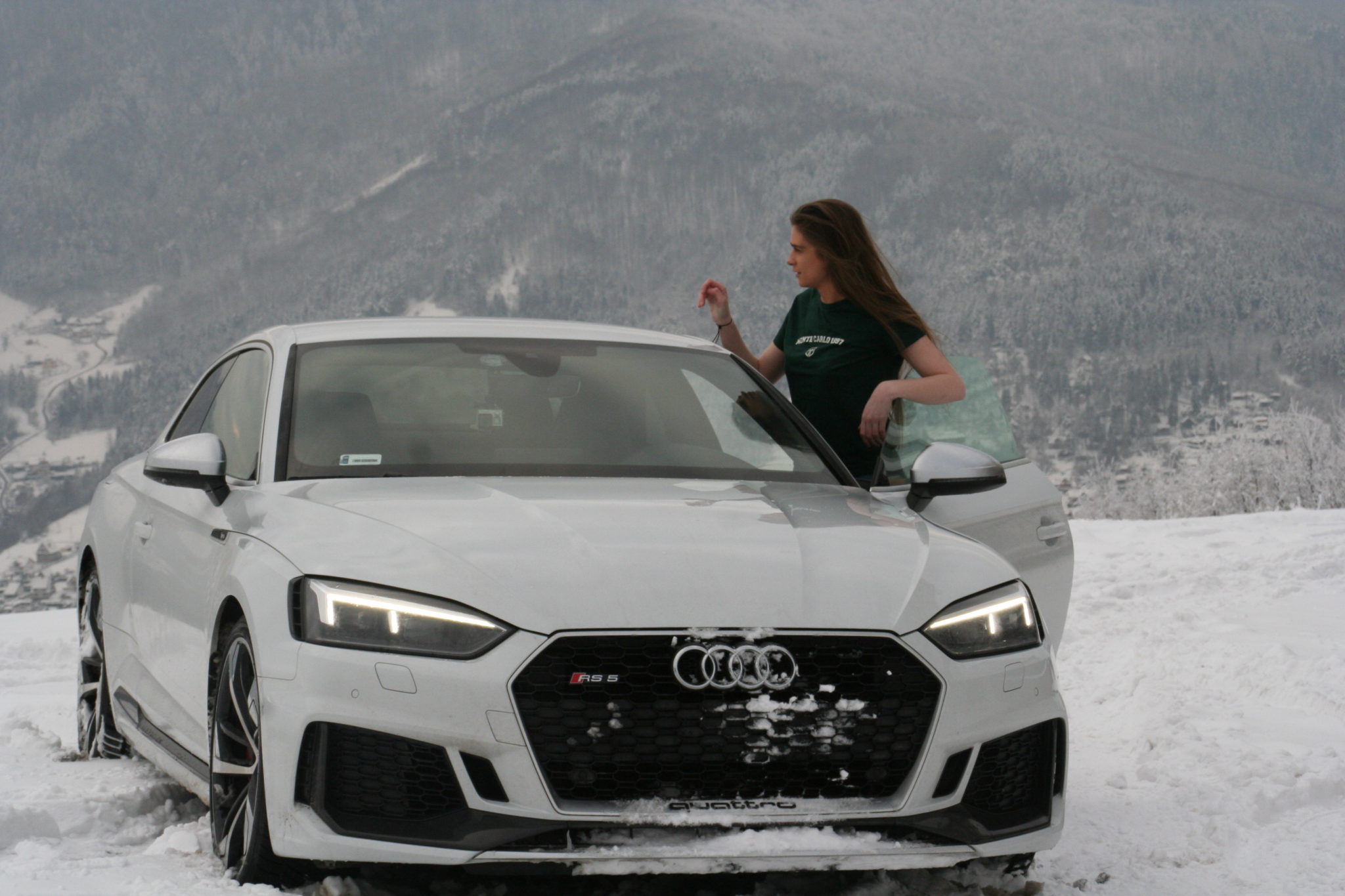 Dziewczyna stojąca przy białym samochodzie