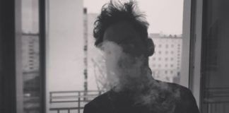 Mężczyzna wypuszczający dym z papierosa