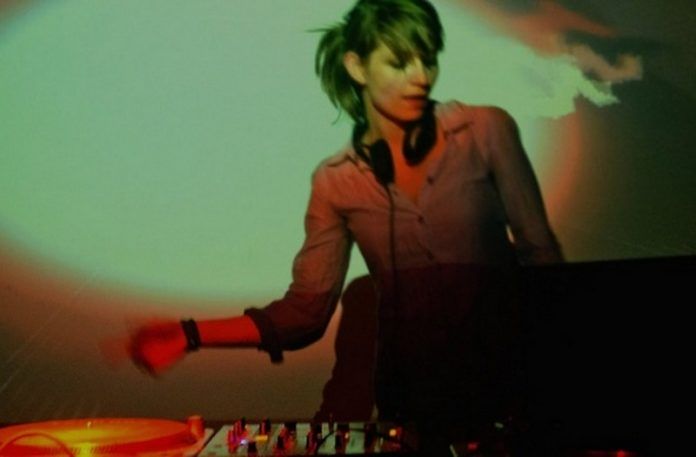 Dziewczyna stojąca przy konsolecie DJskiej